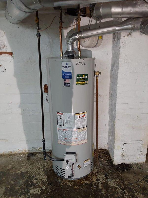 Installed a 50-gallon Bradford White water heater to code in basement utility room. Completed all copper piping connections with brass fittings and valves, installed proper ventilation ductwork with metallic flex piping routed across ceiling joists, and connected gas line with shutoff valve. All plumbing connections, venting, and safety components were installed per manufacturer specifications and local code requirements.