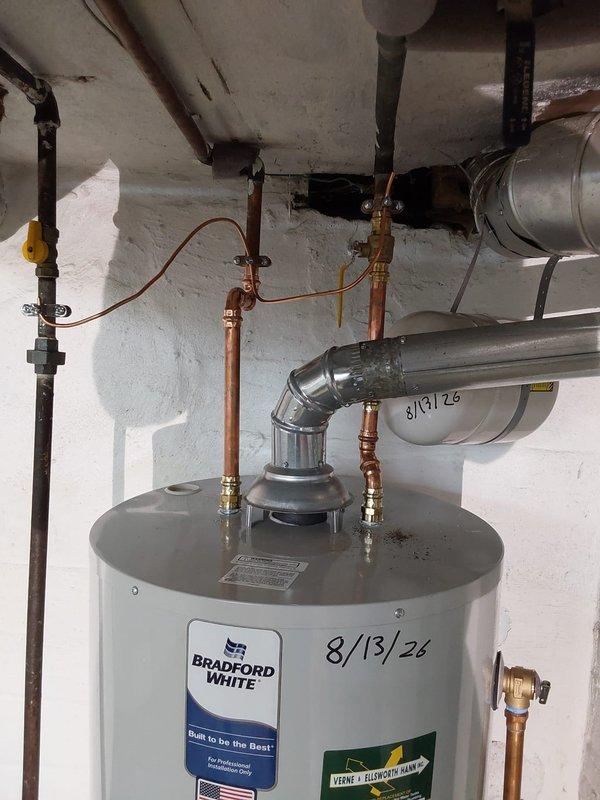 Installed a 50-gallon Bradford White water heater to code in basement utility room. Completed all copper piping connections with brass fittings and valves, installed proper ventilation ductwork with metallic flex piping routed across ceiling joists, and connected gas line with shutoff valve. All plumbing connections, venting, and safety components were installed per manufacturer specifications and local code requirements.