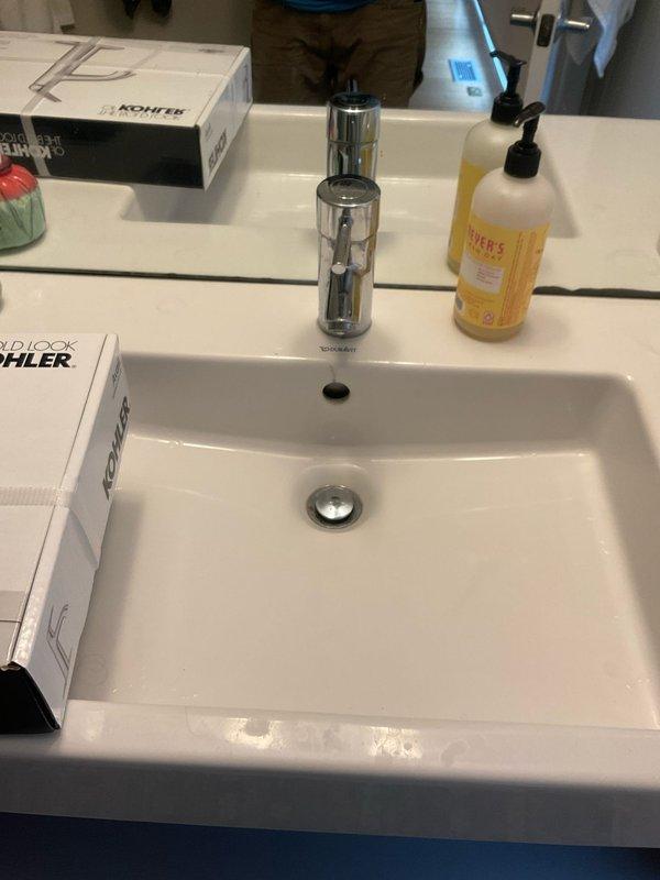 Completed installation of two chrome faucets, including a modern single-handle bathroom faucet with pop-up drain assembly mounted on white rectangular sink. Verified proper water supply connections with braided stainless steel flex lines to angle stop valves and confirmed leak-free operation of all fixtures.
