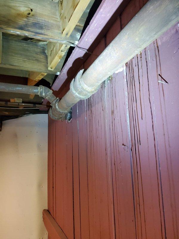 Returned to property following asbestos abatement around affected piping to assess and estimate repair of water-damaged plumbing system. Documented exposed pipe insulation deterioration and extensive water staining on basement surfaces, with evidence of ongoing moisture infiltration through compromised pipe insulation and structural components. Provided repair estimate for pipe replacement and remediation of water damage to complete work that was previously inaccessible due to asbestos concerns.