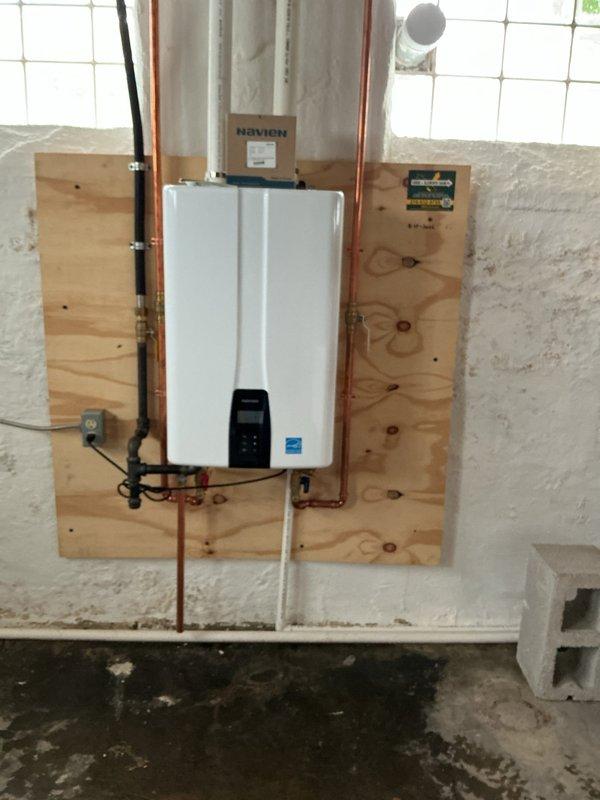Completed annual maintenance service on wall-mounted Navien tankless water heater unit installed in basement utility area. Performed comprehensive flush procedure to remove mineral buildup and sediment accumulation, descaled heat exchanger components, inspected copper supply lines and shutoff valves for proper operation, verified digital control panel functionality and error code history, and confirmed Energy Star-rated unit maintained optimal performance specifications for continued efficient hot water delivery.