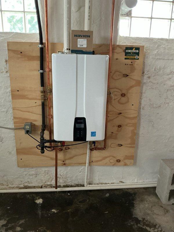 Completed annual maintenance service on wall-mounted Navien tankless water heater unit installed in basement utility area. Performed comprehensive flush procedure to remove mineral buildup and sediment accumulation, descaled heat exchanger components, inspected copper supply lines and shutoff valves for proper operation, verified digital control panel functionality and error code history, and confirmed Energy Star-rated unit maintained optimal performance specifications for continued efficient hot water delivery.