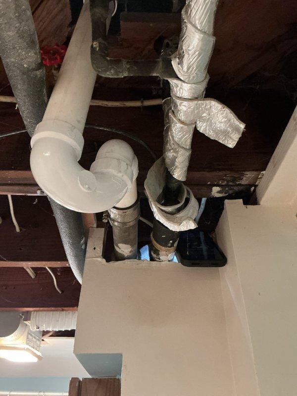 Performed plumbing assessment for toilet replacement in basement and inspected secondary toilet. Evaluated floor drain showing significant water damage and staining around fixture, indicating potential drainage issues or past overflow events. Examined exposed plumbing infrastructure including PVC P-trap configuration and drainage system beneath floor joists. Provided estimates for basement toilet replacement and recommended drain snaking service for shower drain to address blockage concerns.