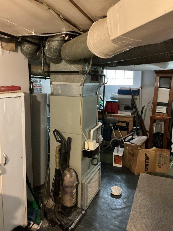 Responded to emergency service call for non-cooling central air conditioning system approximately fifteen years old. Evaluated existing HVAC equipment located in basement utility area and assessed outdoor condensing unit placement relative to property lines and neighboring addresses. Documented system layout, equipment condition, and site configuration to provide comprehensive replacement estimate for aging air conditioning system that had reached end of serviceable life.