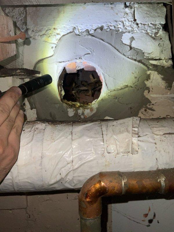 Completed comprehensive boiler repair including piping modifications and system component replacement in basement mechanical room. Addressed deteriorated piping connections showing significant oxidation, repaired circular wall penetration with compromised insulation, and serviced existing boiler unit including pressure relief valve, control relay, and associated shut-off valves. Coordinated with plumbing contractor for concurrent water heater replacement to ensure integrated system functionality and proper operation of all mechanical components.