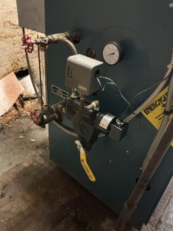 Completed comprehensive boiler repair including piping modifications and system component replacement in basement mechanical room. Addressed deteriorated piping connections showing significant oxidation, repaired circular wall penetration with compromised insulation, and serviced existing boiler unit including pressure relief valve, control relay, and associated shut-off valves. Coordinated with plumbing contractor for concurrent water heater replacement to ensure integrated system functionality and proper operation of all mechanical components.