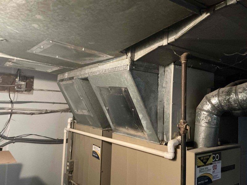 Responded to no cooling complaint on second floor air conditioning system. Evaluated 27-year-old HVAC system including furnace/air handler unit, ductwork, and associated components located in mechanical room. Documented existing equipment condition with photos showing aged system with worn flexible ductwork and standard residential installation configuration. Provided estimate for complete system replacement due to age and inefficiency of current equipment.