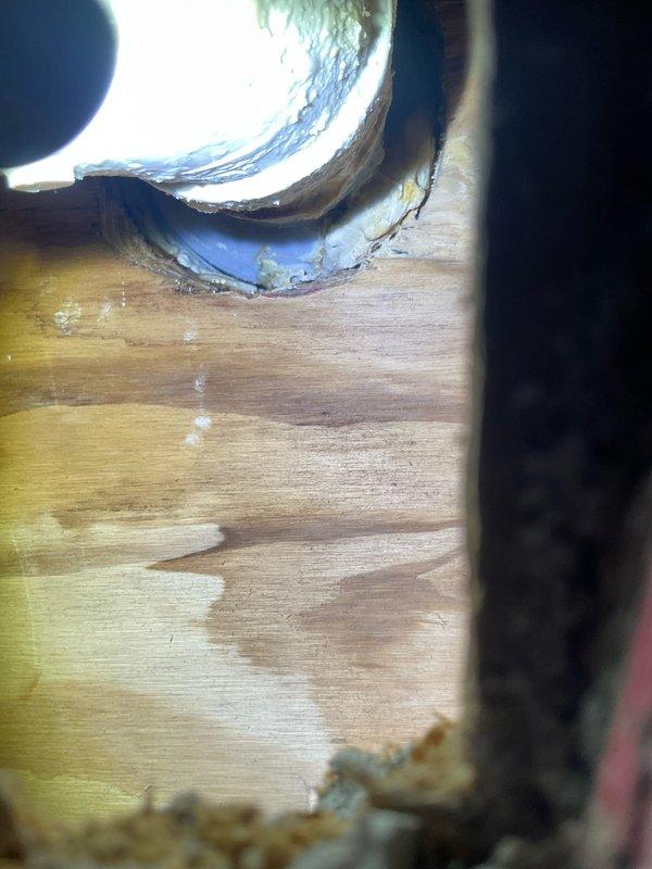 Responded to ongoing water leak issue that remained unresolved after previous service visit. Conducted thorough inspection of plumbing system in crawl space area, examining white supply piping, blue couplings, and brass fittings for source of leak. Investigation revealed significant corrosion and mineral buildup on copper piping connections entering water heater tank, with visible oxidation and turquoise-green patina indicating long-term moisture exposure. Documented extensive water staining and mineral deposits on interior tank surfaces, suggesting persistent leak at pipe penetration point with compromised sealing. Photographed corroded components and deteriorated blue insulation material around connection points to assess extent of damage and determine necessary repairs for permanent resolution of leak issue.