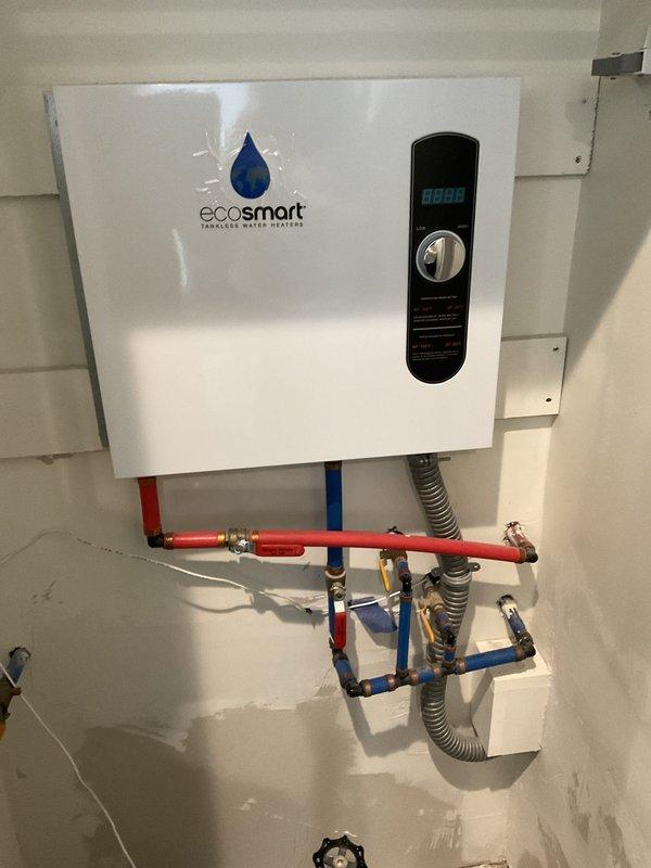 Performed descaling maintenance on a 3-year-old EcoSmart tankless water heater unit. Flushed system with descaling solution to remove mineral buildup, verified proper operation of heating elements and flow sensors, and confirmed unit returned to normal functioning with digital display reading correctly.
