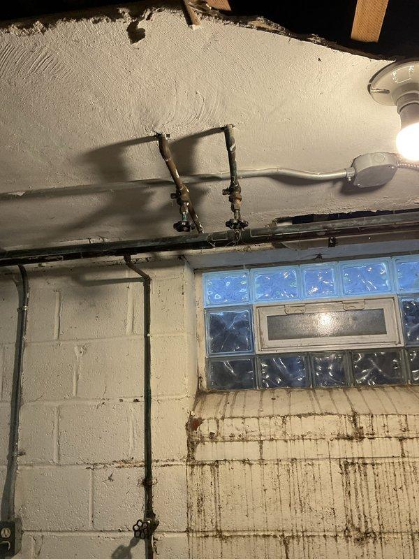 Responded to reported drilling noise from water pipes above downstairs sink in 80-year-old home. Upon arrival, inspected plumbing system and HVAC components in basement utility area near air conditioning unit. Confirmed noise ceased when air conditioning was turned off, indicating AC system rather than plumbing as source of disturbance. Examined copper water supply lines, shutoff valves, and exposed piping running along ceiling joists—all plumbing components found to be secure and functioning properly with no leaks, pressure issues, or risk of pipe burst. Inspected ceiling-mounted ductwork, flexible venting, and HVAC connections in vicinity of reported noise. Determined vibration from air conditioning operation was likely transmitting through adjacent pipes or mounting hardware, creating drilling-like sound. Advised that plumbing system posed no immediate concerns but recommended HVAC specialist evaluate air conditioning unit for loose components, mounting issues, or mechanical problem