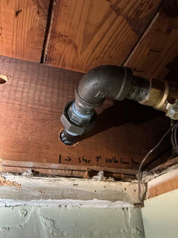 Installed 1.25" x 1" tee fitting in existing gas line system and ran corrugated stainless steel tubing (CSST) across ceiling joists to back wall location. Transitioned from CSST to rigid black iron pipe, then ran polyethylene (PE) pipe underground with two 90-degree sweep elbows and capped termination point to complete gas line extension.