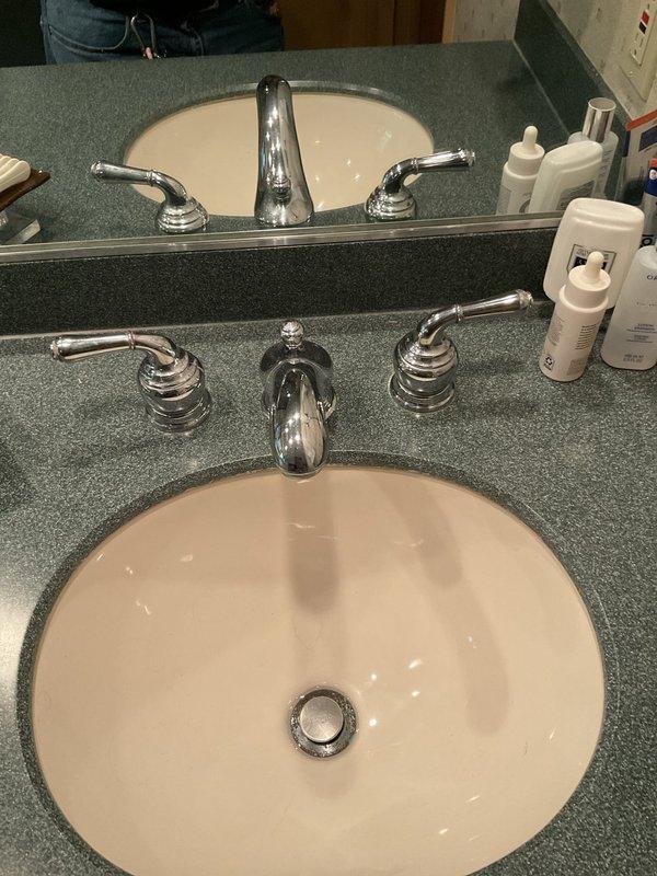 Responded to water leak service call for dripping faucets in bathroom. Upon inspection, found two bathroom vanity sinks and bathtub experiencing continuous dripping from fixtures. Examined double sink vanity setup with three-piece chrome faucet assemblies on both sinks. Identified worn compression washers and deteriorated O-rings in all faucet handles causing the leaks. Disassembled faucet cartridges, replaced faulty washers and seals, and reassembled fixtures. Tested all repaired faucets under full water pressure to verify proper shut-off and confirm elimination of drips. All fixtures now operating correctly with no leaks detected.