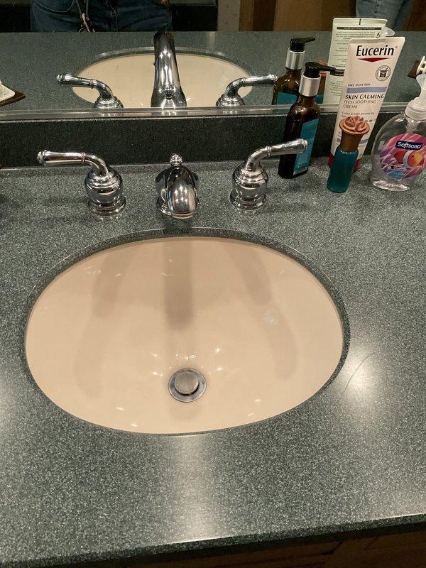 Responded to water leak service call for dripping faucets in bathroom. Upon inspection, found two bathroom vanity sinks and bathtub experiencing continuous dripping from fixtures. Examined double sink vanity setup with three-piece chrome faucet assemblies on both sinks. Identified worn compression washers and deteriorated O-rings in all faucet handles causing the leaks. Disassembled faucet cartridges, replaced faulty washers and seals, and reassembled fixtures. Tested all repaired faucets under full water pressure to verify proper shut-off and confirm elimination of drips. All fixtures now operating correctly with no leaks detected.