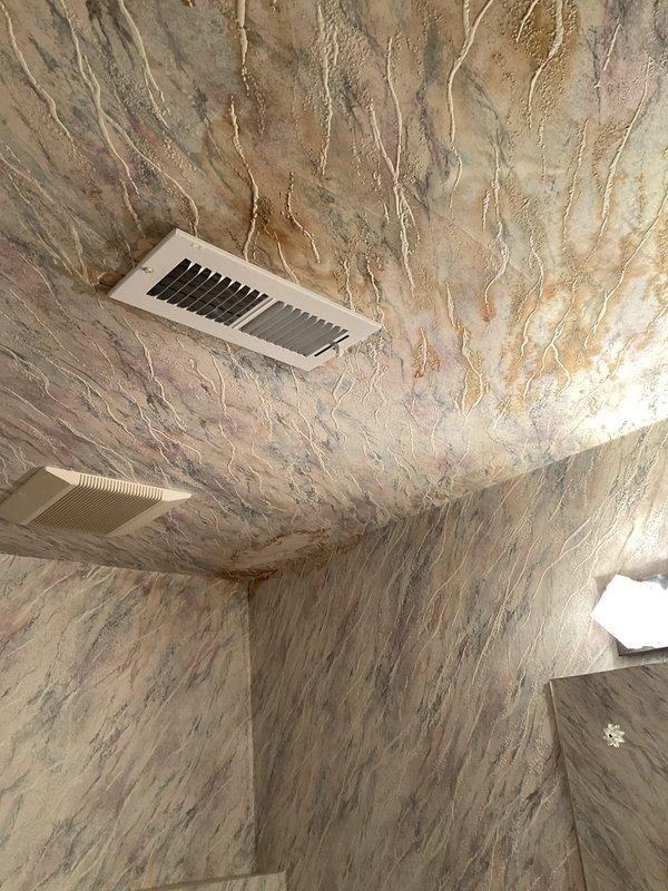 Responded to ceiling leak in basement bathroom originating from upstairs plumbing. Upon inspection, identified water intrusion affecting ceiling near HVAC vent with visible wetness and minor damage to finished surface. Accessed crawl space and inspected supply line plumbing infrastructure, including brass standpipes and shut-off valves serving both bathroom fixtures. Verified integrity of copper supply lines and valve connections. Documented existing plumbing configuration and insulated areas showing moisture penetration patterns. Recommended monitoring for additional leakage and further investigation of upstairs bathroom fixture connections to determine exact source of water intrusion.