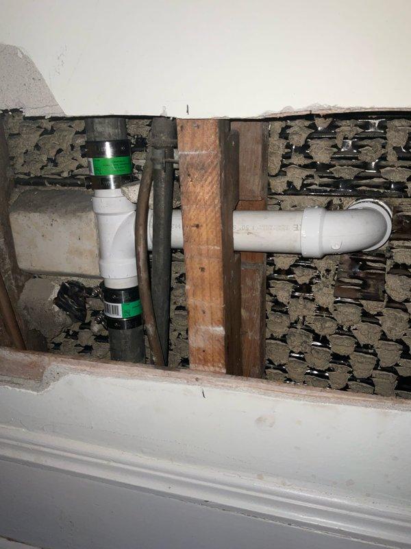 Accessed the master bedroom wall behind the second-floor bathroom pedestal sink to expose defective drain fittings. Removed old fittings and installed new PVC piping with mission band connections inside the wall cavity. Installed new PVC trap assembly on the pedestal sink, connecting it to the existing pop-up drain assembly. Inspected hot and cold shower valve for reported leak. Tested all connections for proper operation and verified no leaks present upon completion.