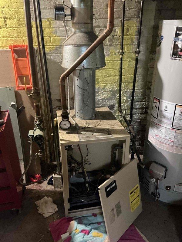 Conducted on-site estimate for boiler system replacement in residential basement mechanical room. Upon inspection, documented existing heating infrastructure including green expansion tank, copper supply piping, and white furnace unit with associated venting system. Assessed current equipment configuration, photographed mechanical components, and provided homeowner with replacement options and recommendations for new boiler installation.