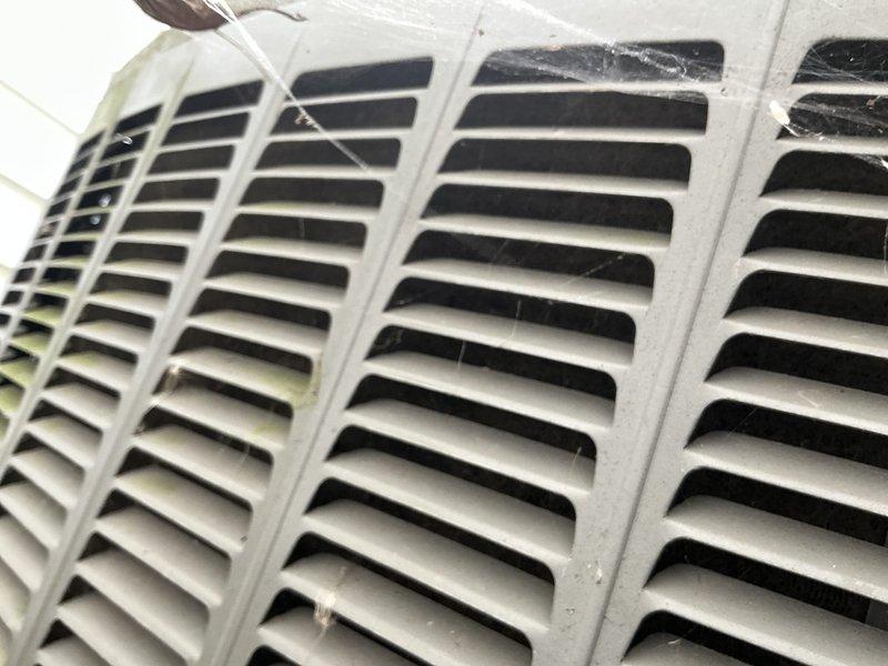 Responded to service call for frozen evaporator coil on 17-year-old air conditioning unit located in basement. Upon arrival, customer had already turned off system and allowed coil to thaw and dry per initial troubleshooting. Inspected evaporator coil assembly and confirmed previous freezing condition. Examined air filter and found significant dust and debris accumulation restricting airflow, which is a primary cause of coil freezing. Inspected return air grille and noted substantial dust buildup and cobwebs on louvers and surrounding areas, further contributing to reduced system airflow. Documented condition of filtration system and ventilation components with photographs showing extent of contamination. Customer indicated concern about potential refrigerant charge requirement; however, restricted airflow from dirty filter and return grille is likely root cause of freezing issue rather than low refrigerant. Advised customer that proper airflow must be restored before any refrigerant a