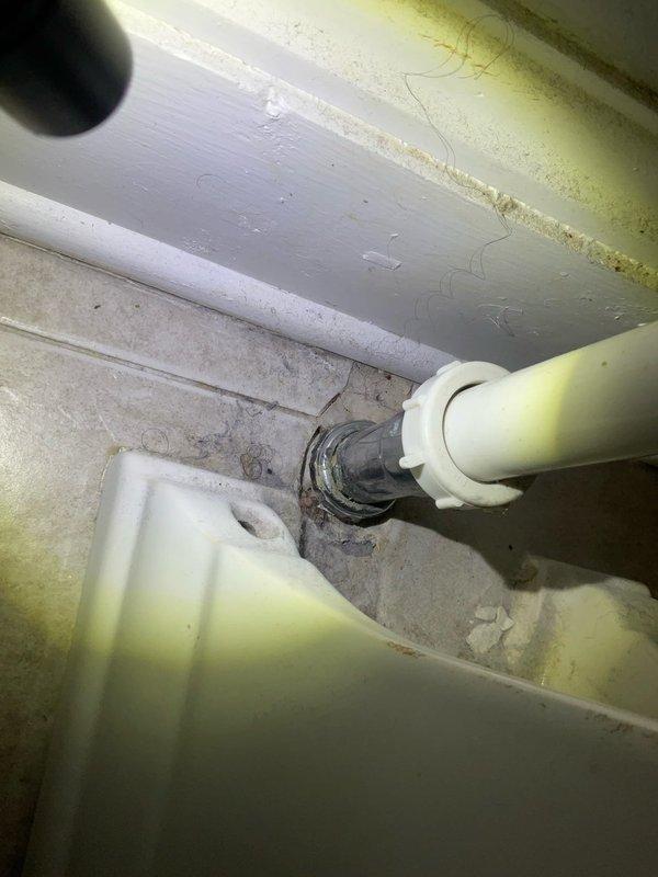Responded to water leak originating from second-floor bathroom and penetrating into foyer below in century-old residential property. Upon arrival, conducted thorough inspection of bathroom fixtures including pedestal sink, bathtub with shower assembly, and toilet to identify source of leak. Examined all visible plumbing connections, drain assemblies, and supply lines. Inspected underside of pedestal sink where drainage pipes penetrate floor, noting aged plumbing components and floor penetration points. Assessed condition of drain collar, pipe connections, and surrounding subfloor area for signs of active water intrusion. Documented existing conditions through photographic evidence showing bathroom layout, fixture placement, and critical plumbing connection points beneath sink where pipes pass through flooring into space below. Leak source identified and necessary repairs completed to prevent continued water damage to lower level.