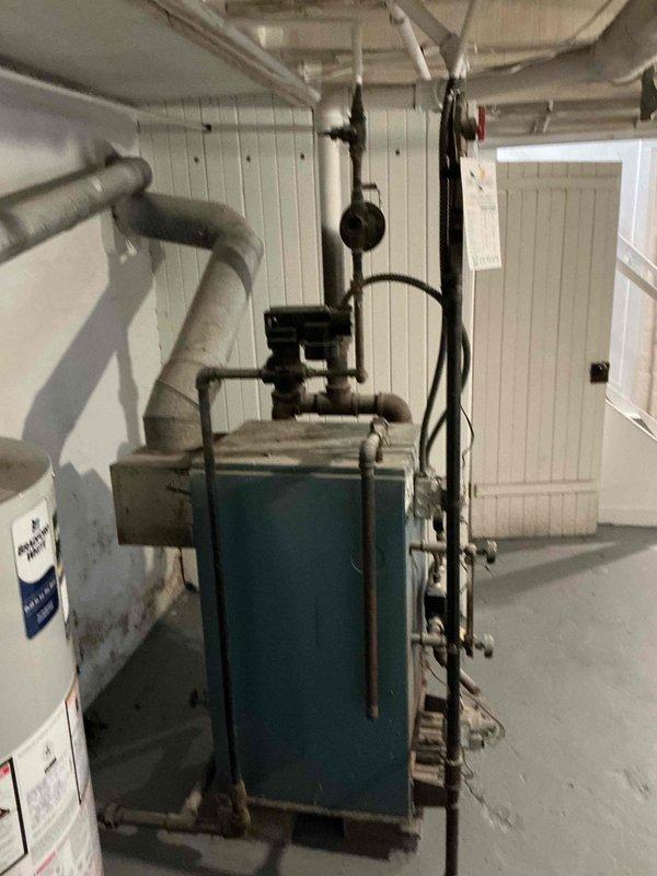 Conducted on-site assessment of existing boiler system located in basement mechanical room to provide replacement estimate. Upon arrival, accessed property via lock box and performed thorough evaluation of aging teal-colored boiler unit, associated piping infrastructure, and installation conditions. Documented current system configuration including insulated supply lines, pipe connections, and mechanical room layout through photographic documentation. Assessed basement structural elements, clearances, and access points to determine replacement requirements and installation parameters for new boiler system.