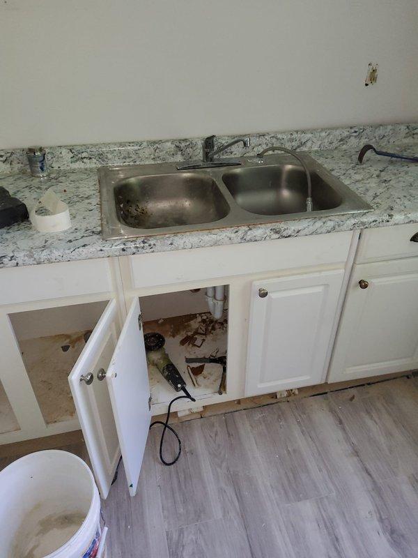 Responded to follow-up service call for persistent low water pressure issue previously assessed in May. Technician arrived early morning to diagnose and address water pressure concerns affecting both bathroom and kitchen fixtures. Upon inspection, examined shower assembly, bathtub fixtures, and kitchen sink plumbing system. Investigated potential causes including clogged aerators, partially closed shut-off valves, and sediment buildup in supply lines. Assessed condition of existing plumbing infrastructure, including PVC drain lines and supply connections visible beneath kitchen sink cabinet. Documented current state of fixtures and plumbing components through photographic evidence showing bathroom shower system with vertical chrome piping and kitchen sink area with exposed under-cabinet plumbing. Confirmed water pressure levels at multiple fixtures to establish baseline measurements and identify affected areas throughout the property.