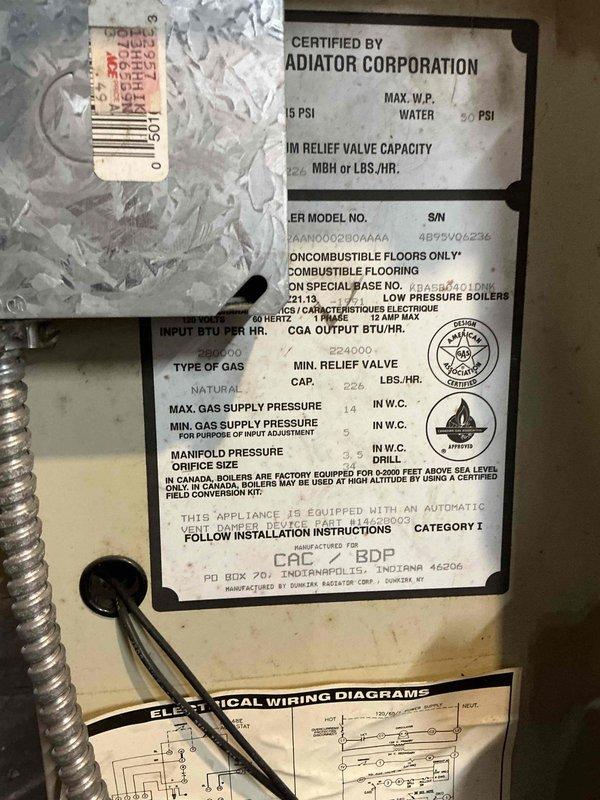 Conducted comprehensive assessment of aging 30-year-old commercial-grade boiler system located in basement mechanical room with exposed brick construction. Upon inspection, identified unit manufactured by Adiator Corporation showing significant age-related deterioration and requiring extensive repairs that would be cost-prohibitive relative to equipment value. Documented all specification label information including maximum water pressure ratings, relief valve capacity, input BTU/HR, natural gas specifications, and serial number data. Photographed complete system configuration including copper piping connections, circulation pump assembly with electrical wiring, vertical venting arrangement, and overall installation layout to support replacement recommendation. Prepared detailed estimate for commercial-sized boiler replacement given the advanced age of existing equipment and anticipated ongoing maintenance costs.