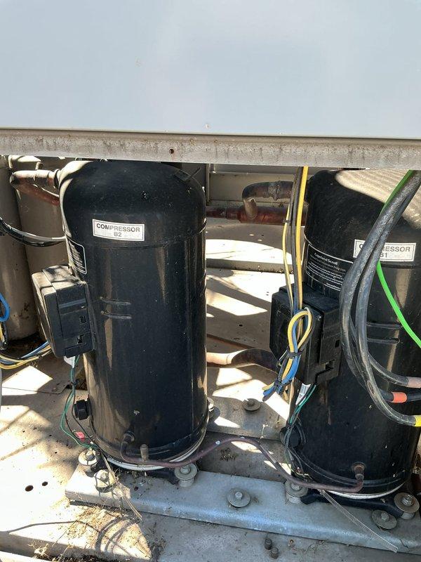 Responded to service call for rooftop Carrier Gemini Select unit with reported coil leak. Inspected dual compressor system and evaporator coil assembly, documented equipment condition and leak location with photos for service records. Unit requires coil repair or replacement to resolve refrigerant leak issue.