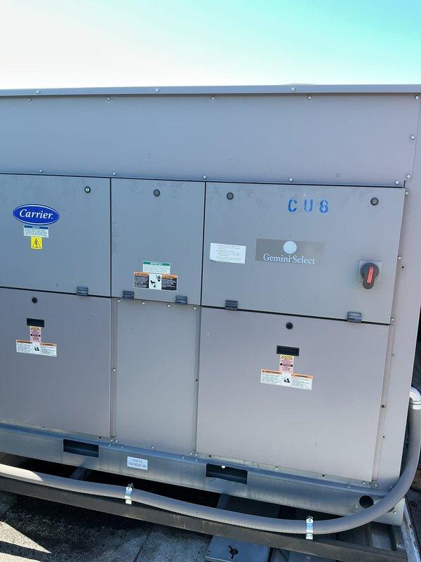 Responded to service call for rooftop Carrier Gemini Select unit with reported coil leak. Inspected dual compressor system and evaporator coil assembly, documented equipment condition and leak location with photos for service records. Unit requires coil repair or replacement to resolve refrigerant leak issue.