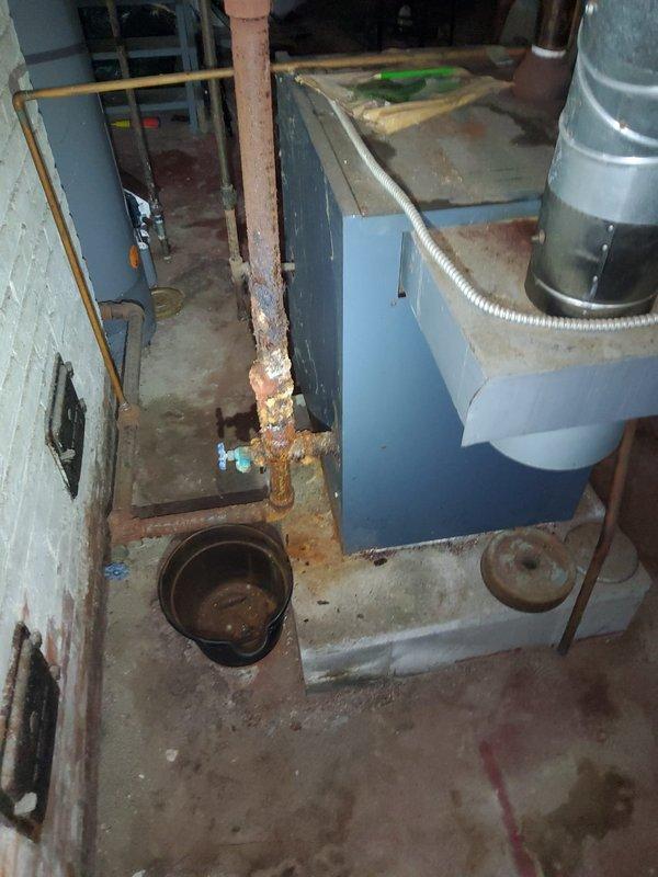 Responded to gas leak service call and measured 120 standard cubic feet of gas leakage in basement area. Upon inspection, identified severely corroded copper gas line supplying the stove, with extensive rust deterioration and flaking at base and lower sections requiring complete line replacement. Coordinated with property occupant regarding temporary gas shutoff procedures and documented equipment conditions with photographs for replacement planning.