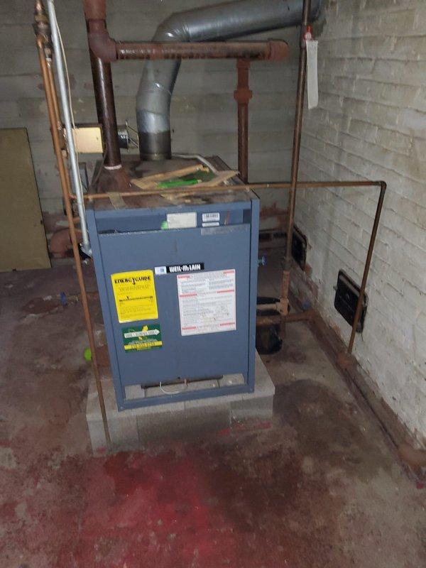 Responded to gas leak service call and measured 120 standard cubic feet of gas leakage in basement area. Upon inspection, identified severely corroded copper gas line supplying the stove, with extensive rust deterioration and flaking at base and lower sections requiring complete line replacement. Coordinated with property occupant regarding temporary gas shutoff procedures and documented equipment conditions with photographs for replacement planning.