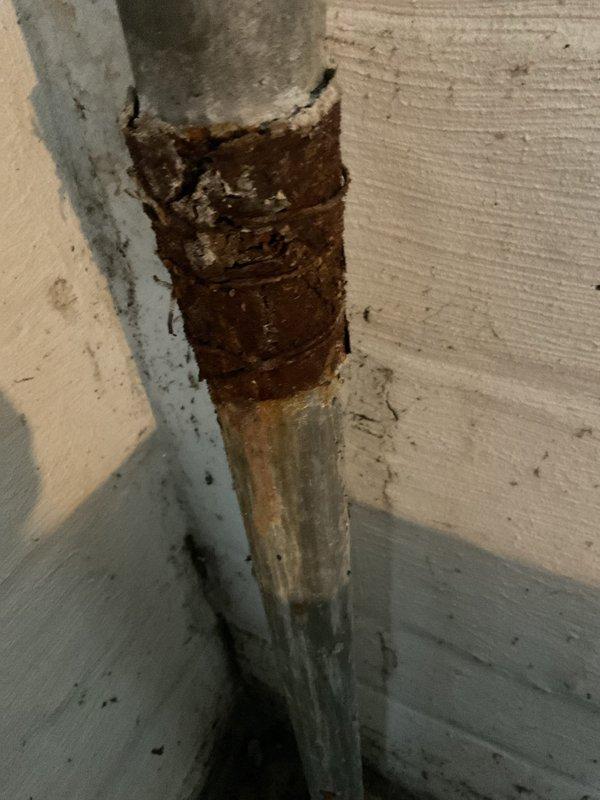 Responded to a clogged kitchen sink call and performed diagnostic inspection of the drainage system. Upon arrival, examined the P-trap assembly and associated PVC plumbing connections beneath the sink, which appeared to be in standard operational condition. Additionally inspected the vertical drain pipe where it exits through the floor, noting significant rust and corrosion buildup on the metal piping that may require future attention to prevent potential drainage issues or structural failure of the pipe.