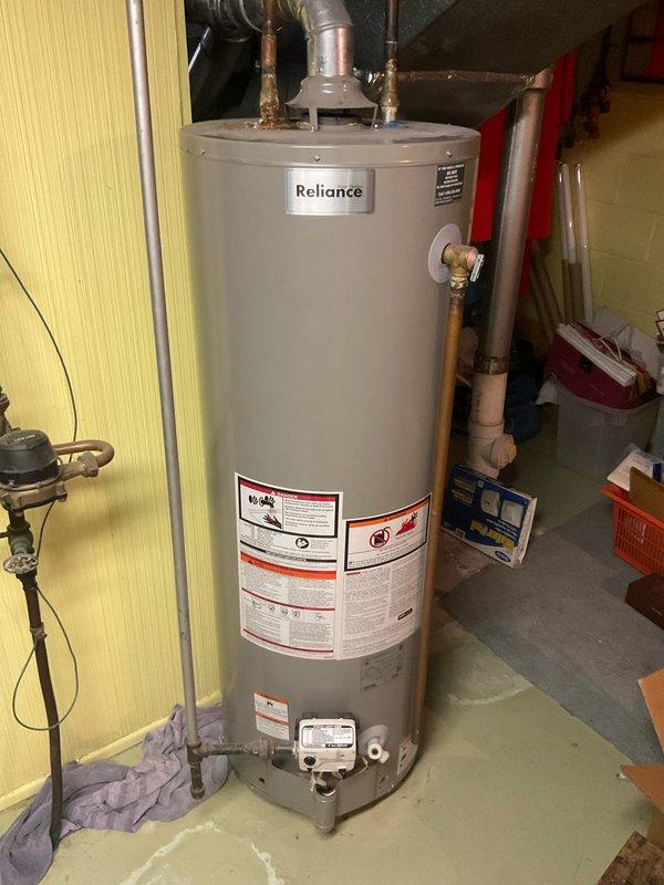 Conducted on-site assessment of existing Reliance brand tanked water heater for replacement estimate. Inspected current installation including copper supply piping, brass shutoff valves, metal vent ducting, and associated plumbing connections. Evaluated utility space configuration, existing infrastructure, and clearance requirements for new unit installation. Documented current water heater specifications, venting system, and connection points. Photographed existing equipment and surrounding mechanical systems to determine replacement requirements and material needs for future installation.