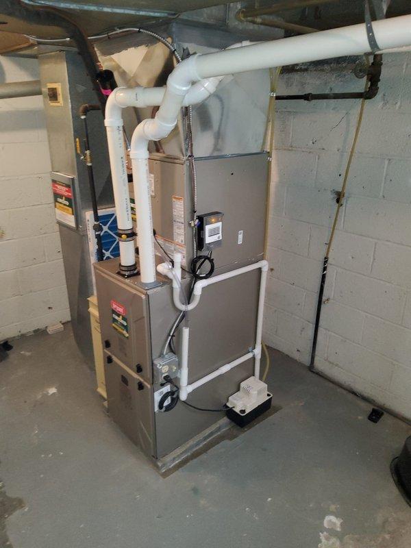 Completed full HVAC system installation including new furnace with evaporator coil, two-stage air conditioning unit, and Ecobee smart thermostat. The furnace was installed in the basement utility area with proper PVC venting for condensate drainage and combustion air intake/exhaust. All ductwork connections were secured, electrical wiring completed to code, and system commissioned with pressure testing showing optimal readings. The installation provides efficient climate control with smart thermostat integration for enhanced energy management.
