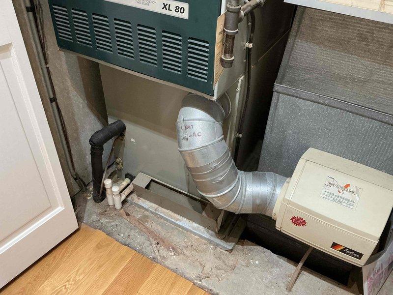 Performed estimate for complete HVAC system replacement on 24-year-old furnace and air conditioning unit presenting with no cooling condition. Assessed XL 80 furnace in basement utility space with associated humidifier and ductwork, along with outdoor cylindrical condenser unit showing significant age-related deterioration including surface discoloration and biological growth. Recommended full system replacement due to age of equipment exceeding expected service life and current system failure.