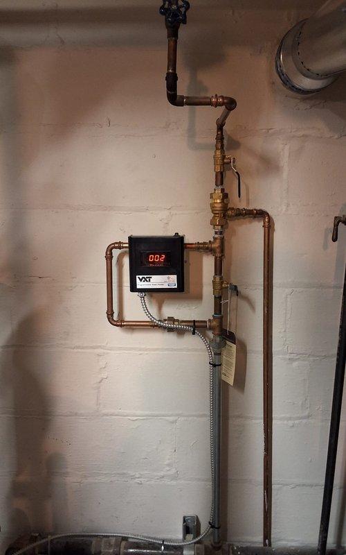 Completed full installation of Peerless Model 64-09 steam gas boiler system including all near boiler piping modifications, new automatic water feeder with digital display, backflow preventer, vaporstat pressure control for enhanced system operation, sight glass, and digital programmable thermostat. Installed new flue pipe assembly to chimney with proper venting connections and configured all copper supply lines, brass fittings, and control valves to ensure optimal steam distribution and system safety.