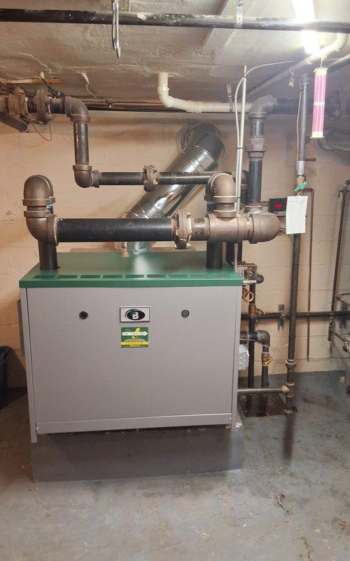 Completed full installation of Peerless Model 64-09 steam gas boiler system including all near boiler piping modifications, new automatic water feeder with digital display, backflow preventer, vaporstat pressure control for enhanced system operation, sight glass, and digital programmable thermostat. Installed new flue pipe assembly to chimney with proper venting connections and configured all copper supply lines, brass fittings, and control valves to ensure optimal steam distribution and system safety.