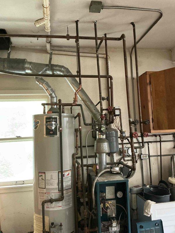 Conducted estimate for non-functioning boiler system in garage mechanical room. Evaluated existing equipment including aging teal-colored boiler unit, cylindrical water heater, and associated piping infrastructure. Provided customer with two options: combination boiler system and standard boiler replacement to restore heating functionality.