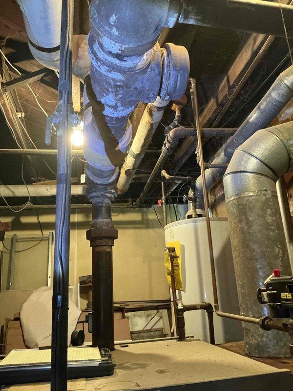 Completed comprehensive boiler replacement estimate for residential property. Assessed existing heating system infrastructure, including aged piping network with mixed materials showing significant wear, deteriorated insulation, and cobweb accumulation indicating limited recent maintenance. Documented current mechanical room configuration featuring vertical ductwork, water heater placement, and copper and galvanized piping with multiple joints and connections. Photographed existing conditions to support equipment sizing recommendations and scope of work development for complete boiler system replacement.