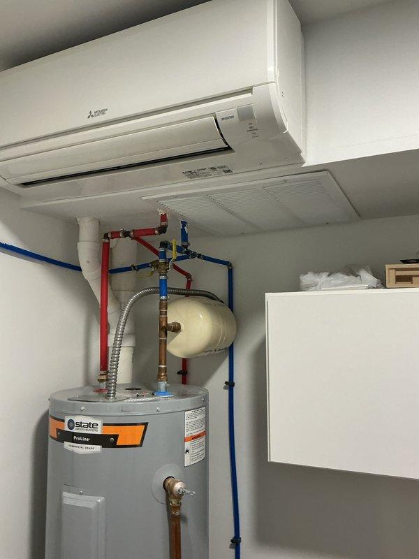 Responded to ongoing leak issue with third-floor Mitsubishi mini-split unit that has persisted since installation. Inspected dual mini-split system mounted above water heater in mechanical room, checked condensate drainage system, refrigerant lines, and mounting integrity to identify source of water leakage. Documented system configuration and current conditions with photos for ongoing resolution of this recurring concern.