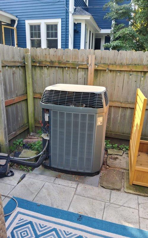 Responded to no cooling call on 20-year-old residential air conditioning system. Upon arrival, performed diagnostic assessment of outdoor condenser unit and indoor air handler/furnace assembly. Inspected 20-year-old outdoor unit positioned on concrete paver patio against perimeter fence, checking for power supply, refrigerant levels, compressor operation, and condenser fan functionality. Evaluated indoor equipment in basement utility room, including furnace, ductwork connections, and associated HVAC components. Noted age-related wear on system components and assessed overall system condition. Documented equipment configuration with outdoor condenser unit and basement-mounted air handler setup connected via refrigerant lines and electrical systems. System evaluated for repair viability versus replacement recommendation given advanced age exceeding typical 15-year service life expectancy for residential AC equipment.