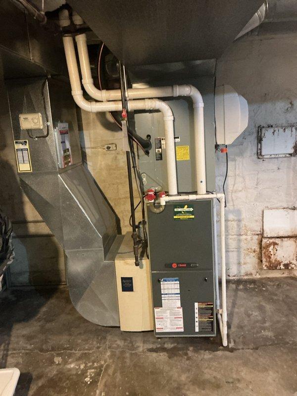 Performed on-site evaluation of 20-year-old air conditioning system with confirmed refrigerant leak. Unit operates on R22 refrigerant, which is being phased out and increasingly expensive to service. Due to the age of the equipment, extent of the refrigerant leak, and obsolete refrigerant type, provided comprehensive replacement estimate for new HVAC system. Documented existing Trane furnace installation in basement mechanical room and outdoor condenser location for proper system sizing and replacement planning.