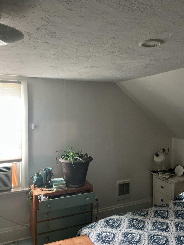 Conducted site evaluation for add-on mini-split installation on second floor living space. Assessed existing electrical panel capacity and verified adequate breaker positions available for new system connection. Evaluated attic bedroom area with sloped ceiling configuration to determine optimal placement for indoor air handler unit, taking into account existing window-mounted cooling unit to be replaced and room layout constraints.