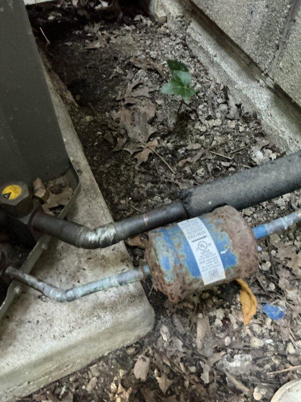 Performed comprehensive tune-up on 15-year-old air conditioning system operating normally at time of service. Inspected outdoor condensing unit, refrigerant lines, and electrical components per standard maintenance protocol. Addressed customer concern regarding gap in foam line insulation on exterior refrigerant lines by inspecting insulation condition and verifying proper coverage. Cleared accumulated debris including leaves and organic matter from around outdoor unit base and foundation area to ensure proper airflow and drainage. Verified all mechanical connections secure and system operating within manufacturer specifications.