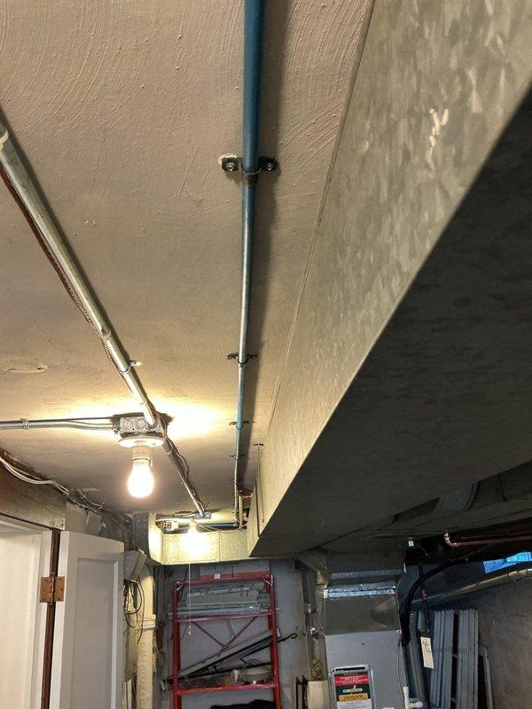 Replaced deteriorated galvanized cold water supply line from manifold to laundry sink with new PEX A tubing routed along basement ductwork. Transitioned from PEX to copper piping at laundry room ceiling to maintain proper electrical grounding continuity for the plumbing system.
