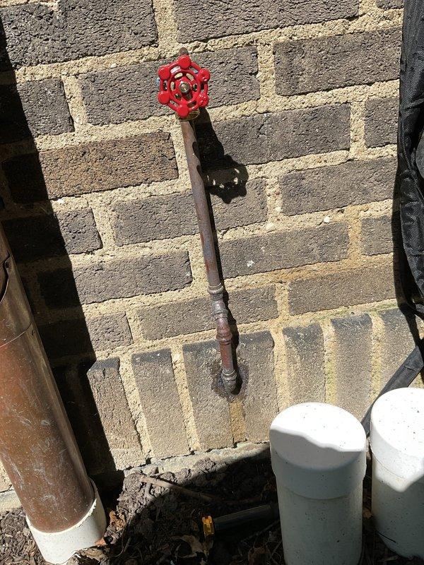 Responded to service call for leaking outdoor faucet that was previously installed by our company. Upon inspection, identified leak at gate valve connection on ground-level spigot with red wheel handle. Repaired valve assembly, tested for proper operation and confirmed leak was eliminated, restoring full functionality to the outdoor water source.