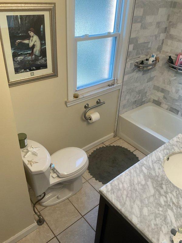 Responded to service call for slow-draining shower in residential bathroom. Upon arrival, inspected shower/tub combination with glass enclosure and identified drainage issue. Assessed plumbing fixtures, drain assembly, and water flow patterns to determine cause of blockage. Provided detailed estimate for drain clearing and repair options to restore proper drainage function. Documented existing bathroom conditions including tiled shower surround, chrome fixtures, and vanity area for service records.