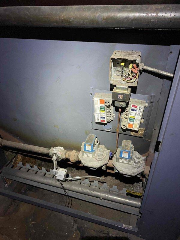 Responded to service call for boiler operating at partial capacity. Upon inspection, found dual-section boiler system with one section not firing properly. Examined electrical connections, gas valves, and control systems on the affected section. Verified gas supply to both zones and inspected burner assembly access panels for proper operation. Documented equipment condition including wiring configuration, gas valve controls with identification labels, and overall system setup for further diagnostic evaluation and repair recommendations.