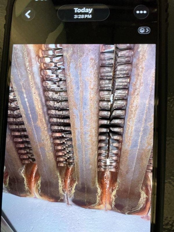 # Boiler Maintenance and Combustion Analysis

Performed comprehensive maintenance on a 10-year-old boiler system under the MVP Heat maintenance program. Conducted thorough inspection of the heat exchanger, which revealed significant rust and corrosion on metal tubes and panels with orange-brown discoloration patterns and oxidation throughout the vertical columns. Documented the deteriorated condition showing heavy moisture exposure and weathering on the heat exchanger components and collection channels.

Completed combustion analysis using digital analyzer, recording CO2 levels at 8.0%, O2 levels at 6.9%, stack temperature at 356.1°F, and stack CO2 at 2.0%. All combustion readings were documented and evaluated to ensure safe and efficient boiler operation. System inspected and maintenance procedures completed per manufacturer specifications.