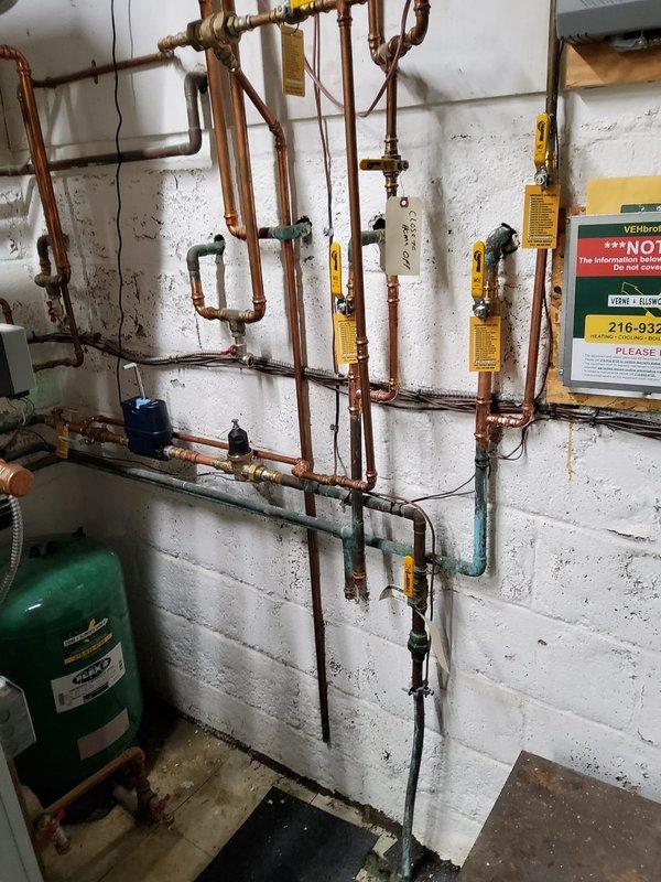 Replaced three defective valves in the existing copper piping system and installed a pressure reducing valve (PRV) with expansion tank to regulate system pressure and accommodate thermal expansion. Added a new isolation valve downstream of the boiler line for improved system control and capped the abandoned line previously connected to the decommissioned steam unit to prevent potential leaks and ensure system integrity.