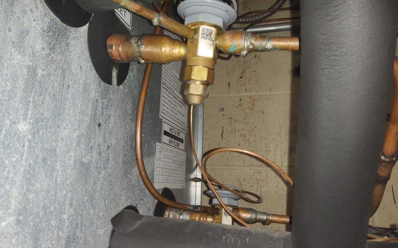 Responded to no cooling call for 2-year-old Carrier rooftop AC unit. Upon arrival, inspected rooftop installation and confirmed unit was not operating. Diagnosed low refrigerant charge caused by leak in system. Located leak, performed necessary repairs, evacuated system, and recharged unit to manufacturer specifications. Verified proper cooling operation, temperature differential, and all safety controls before completing service call.