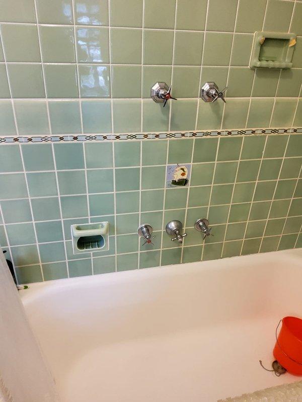 Relocated shower faucet controls from side wall mounting to standard configuration, consolidating multiple valve handles into a single set of controls. Reconfigured plumbing supply lines behind tile wall, installed new valve assembly, and ensured proper water flow and temperature control functionality upon completion.